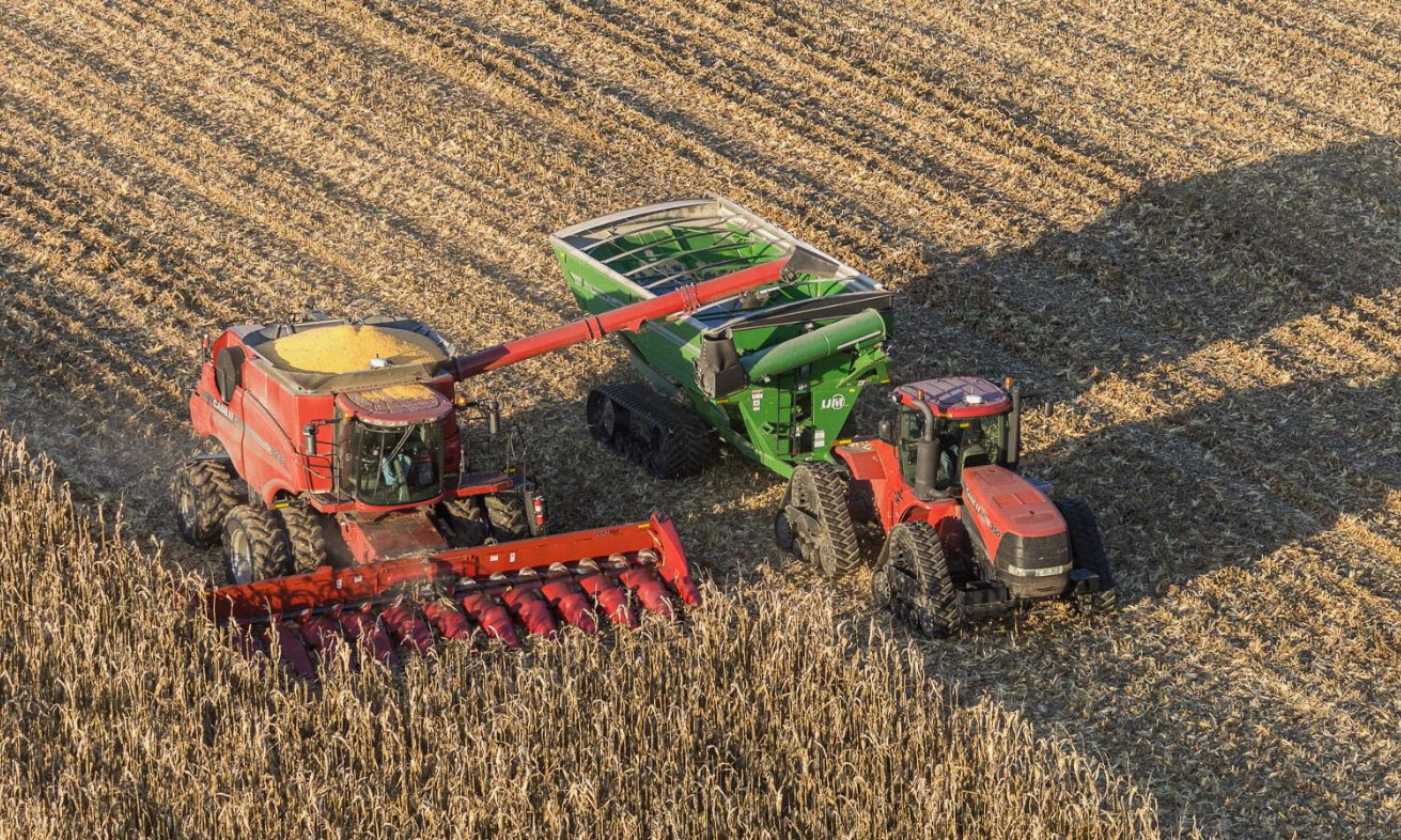 Red tractor working in a cornfield on a farm