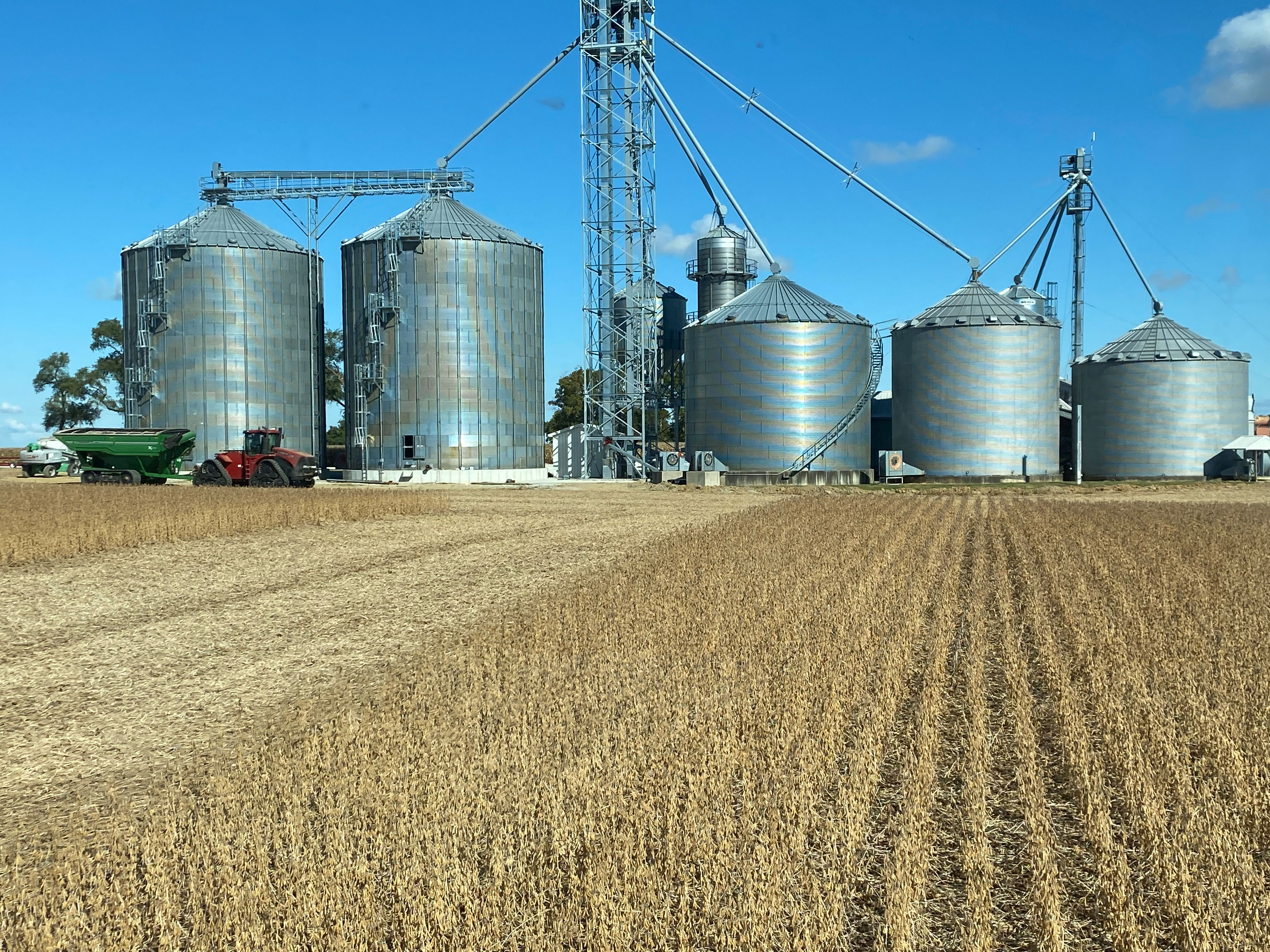 Red combine harvester working in a crop field